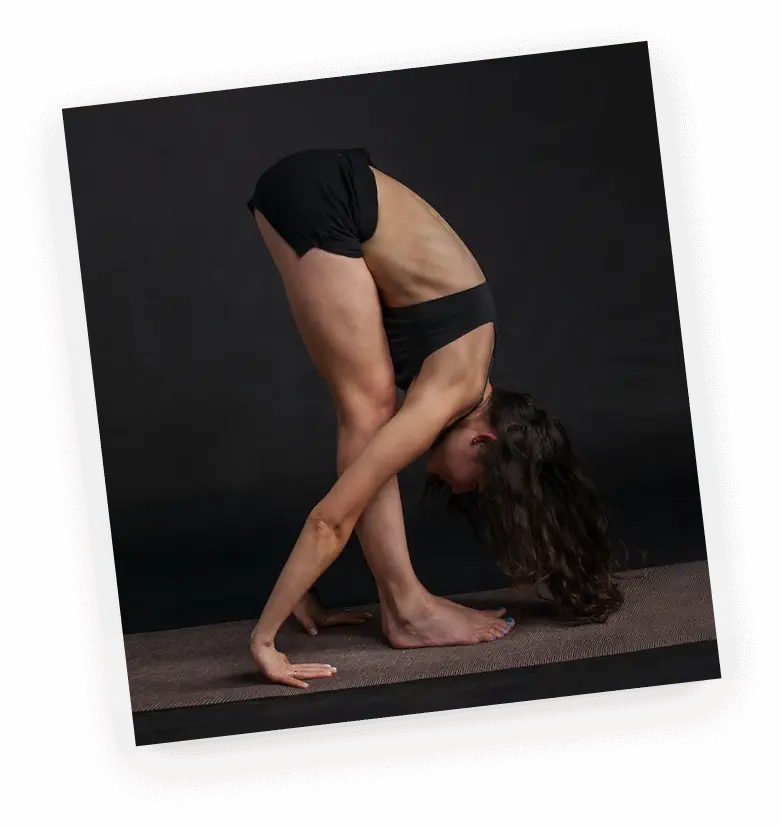 "Fitness Woman in Black Sports Bra Stretching and Reaching Downward" Woman Wearing Black Sports Bra Reaching Floor While Standing